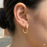 گوشواره حلقه‌ای لبه‌دار طلایی با طراحی زاویه‌دار روی گوش - رنگی‌فا